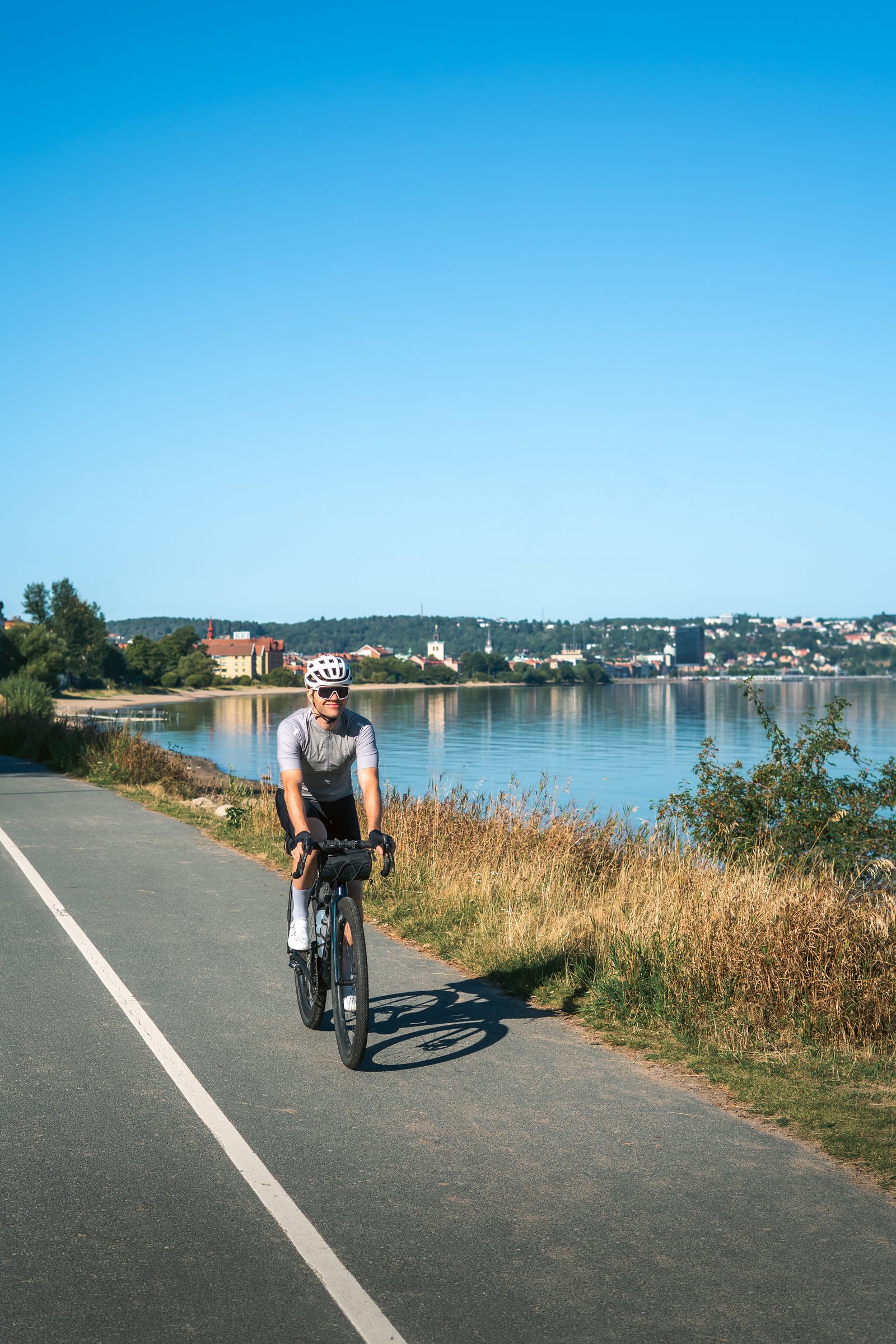 Cyclist riding along the lakeside path out of Jönköping