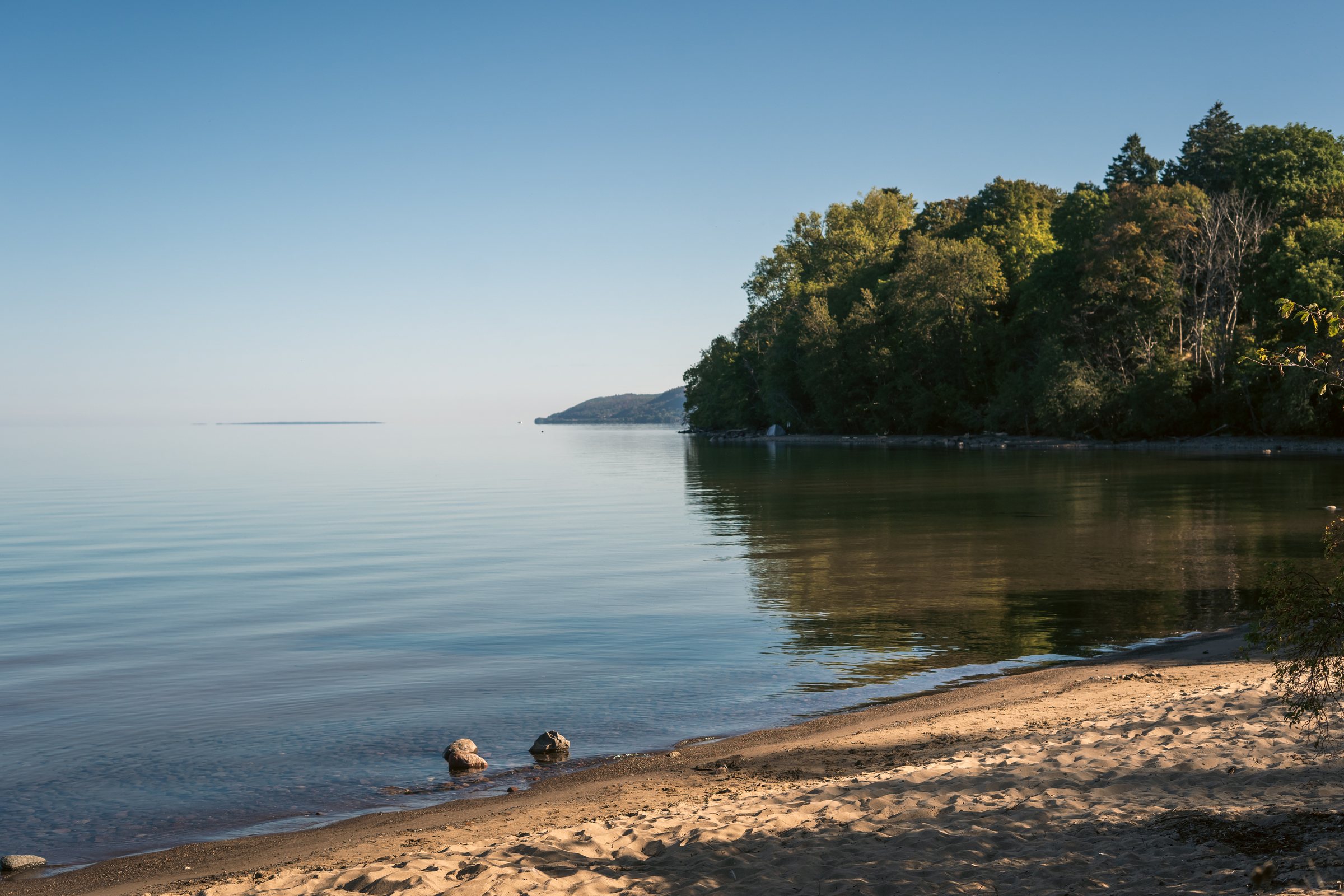 Mirror-calm Lake Vättern and a sandy beach in Jönköping in the morning