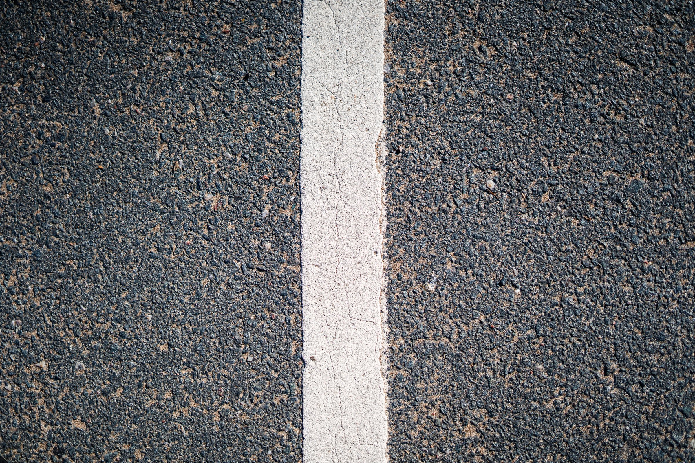 Close-up of the white line on a smooth asphalt cycle path