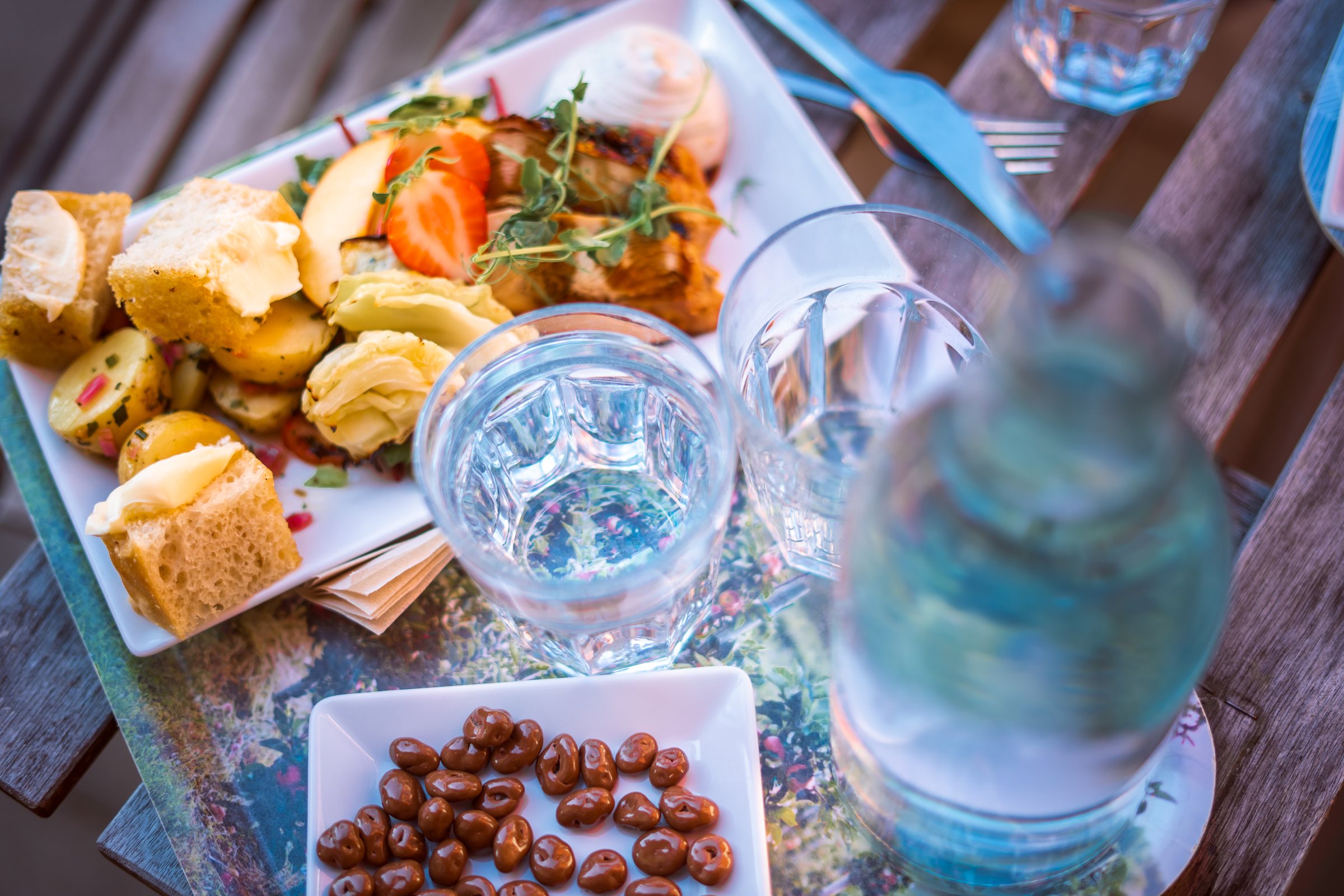 Lunch plate, water glasses and a bowl of chocolate-covered raisins at Rudenstams