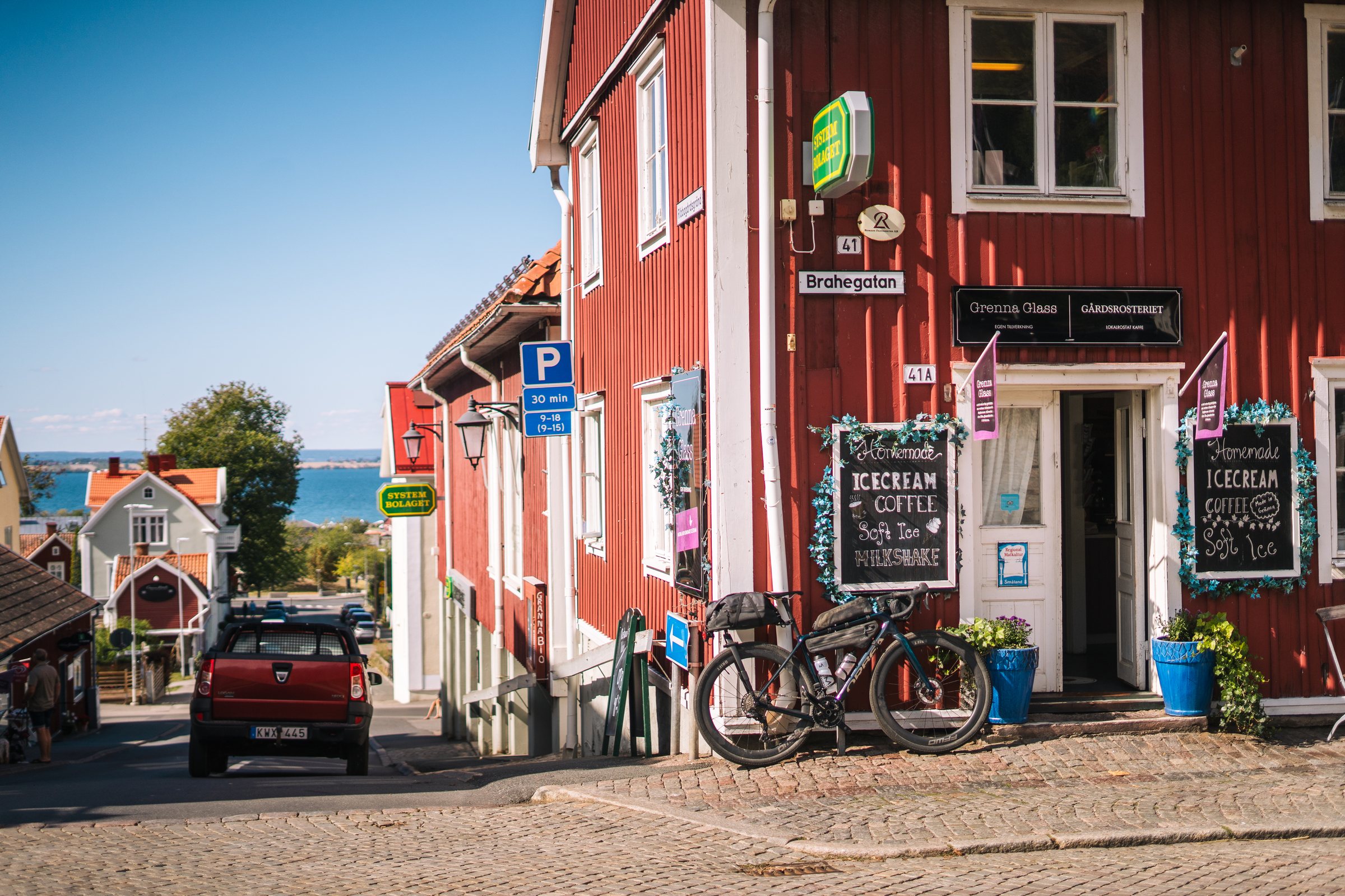 Cobbled street with red wooden houses and parked gravel bikes in Gränna