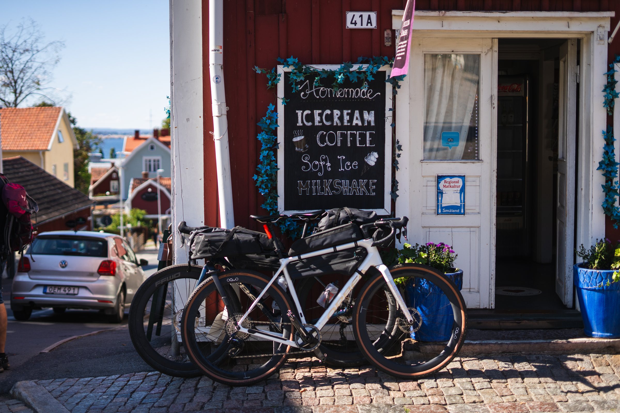 Two loaded gravel bikes outside a homemade ice cream and coffee shop in Gränna