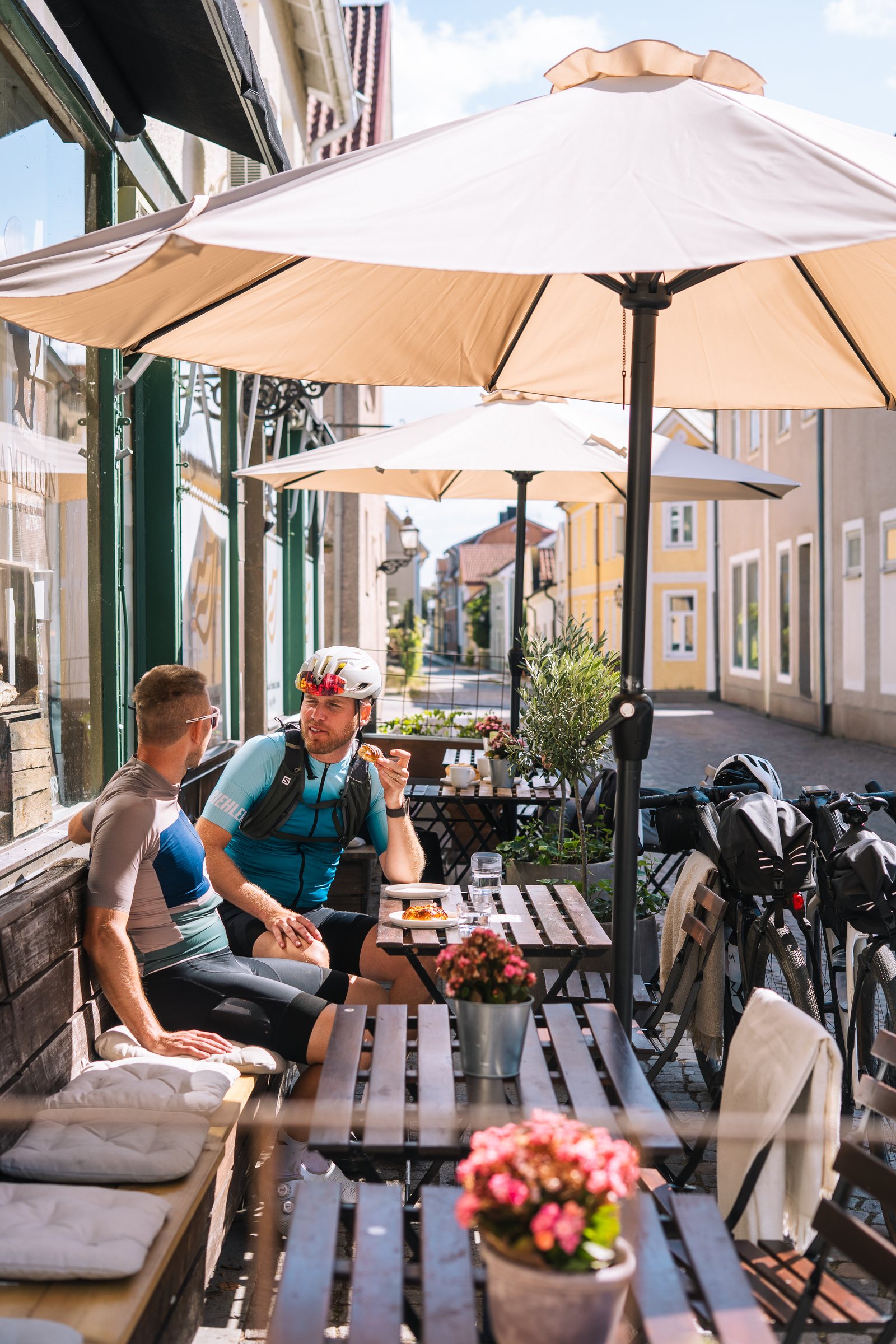Two cyclists having coffee at an outdoor table in Vadstena